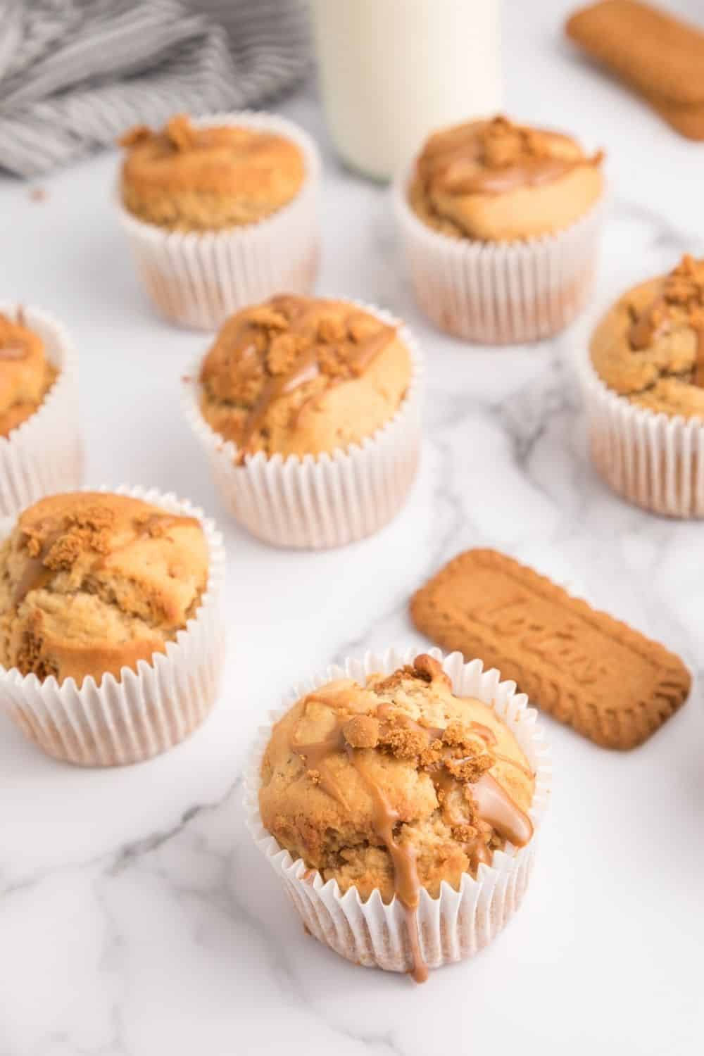 Several muffins made with Biscoff ready to be served. Lotus Biscoff cookies are next to the muffins.