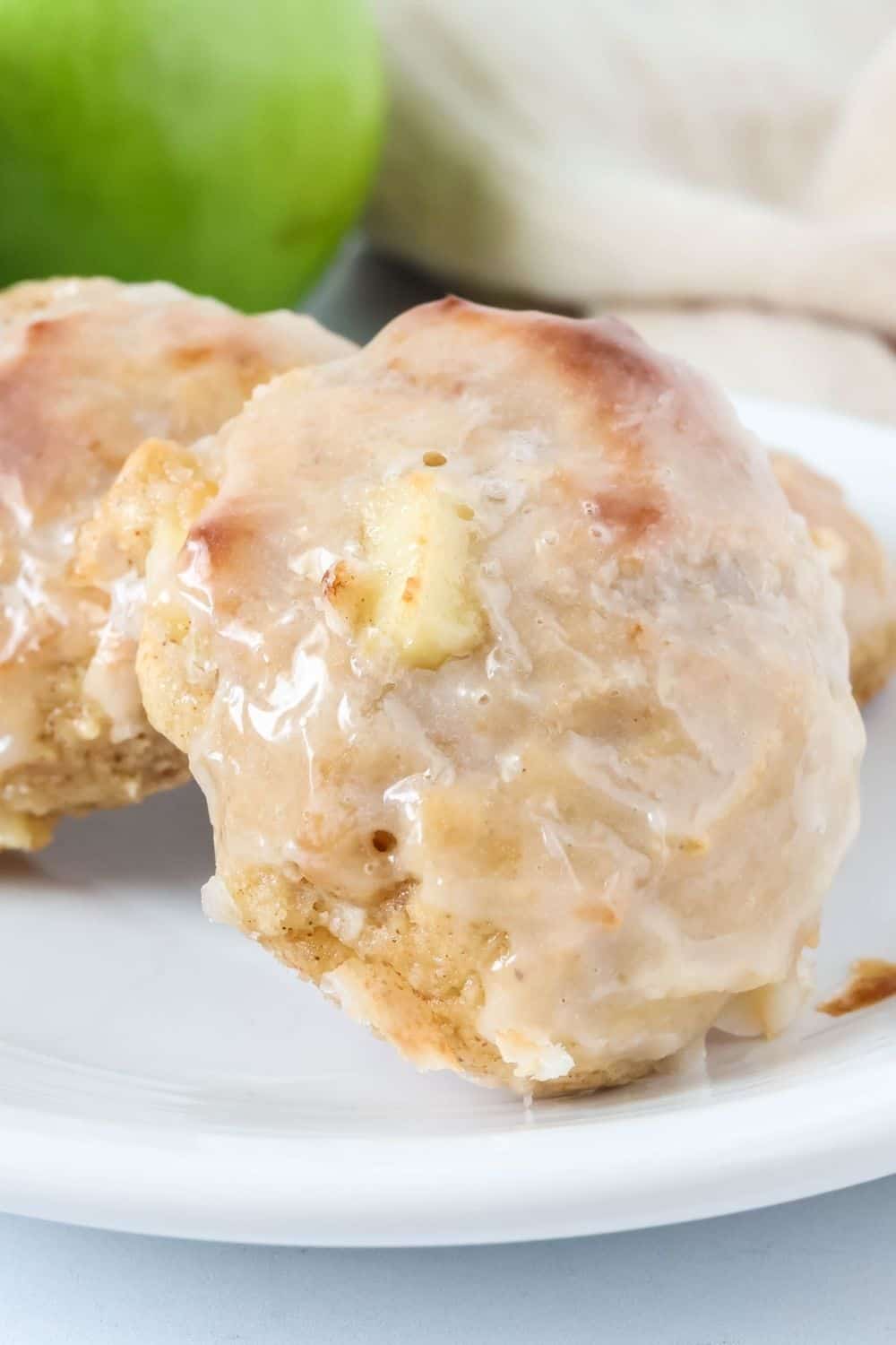 Close-up view of glazed apple fritters that are baked, not fried, served on a white plate.