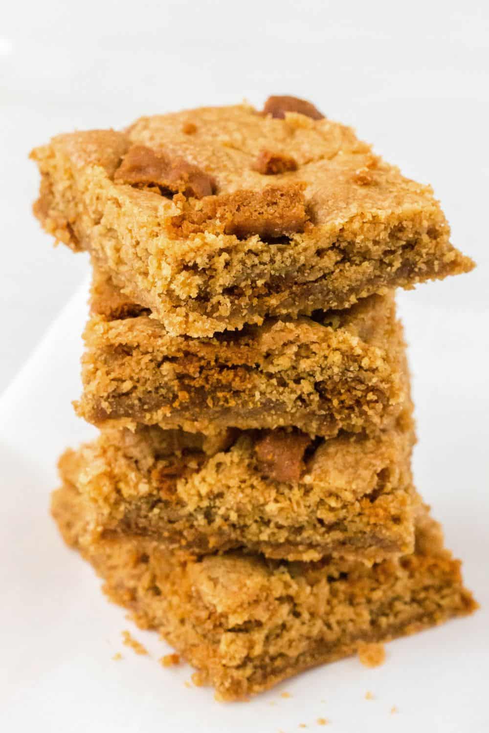 Stack of four Biscoff cookie bars on a piece of parchment paper.