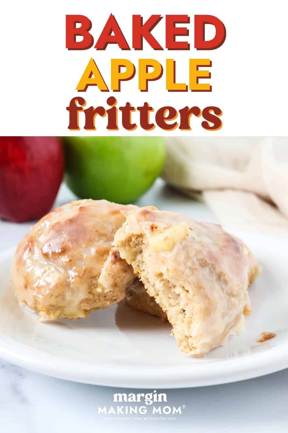 Easy baked apple fritters, topped with glaze, served on a white plate. One fritter has a bite taken out of it to show the soft, moist texture of the interior.