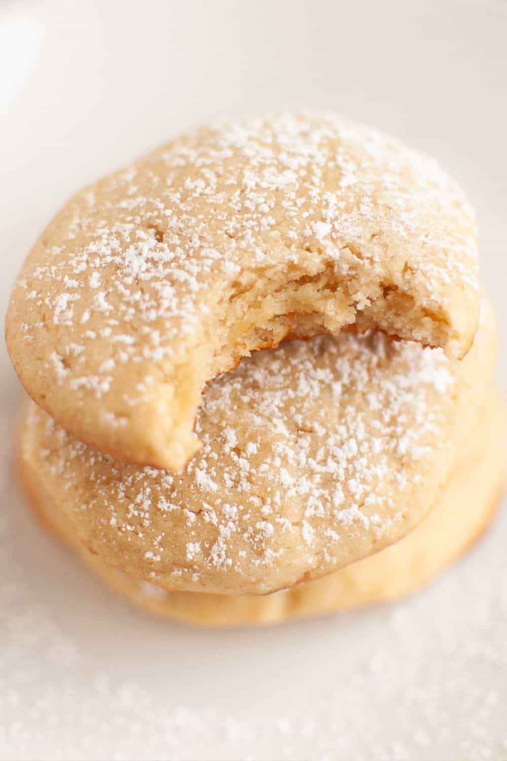 Philadelphia cream cheese cookies stacked together; the top cookie has a bite taken out of it.