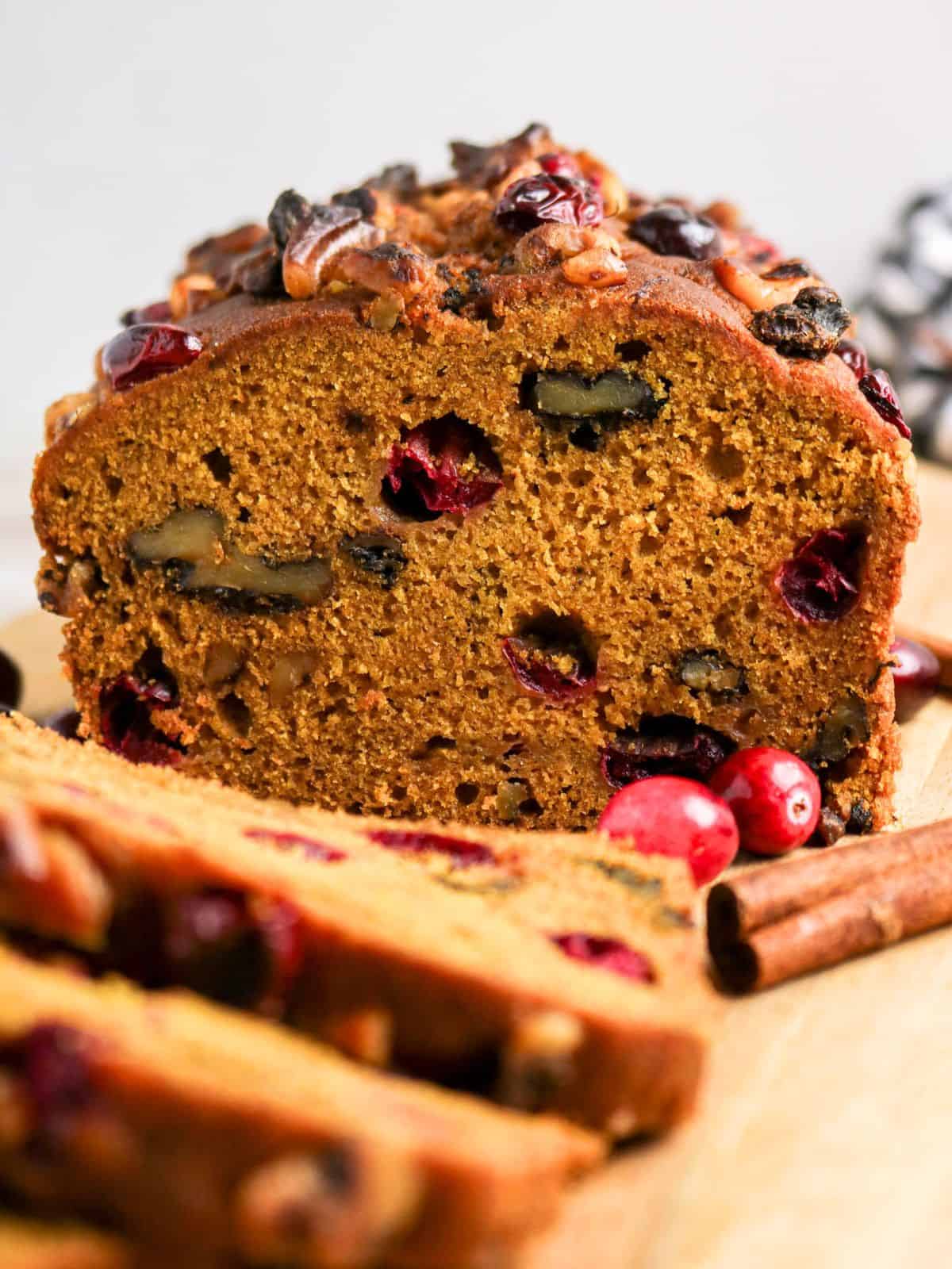 Pumpkin cranberry bread loaf, partially sliced.