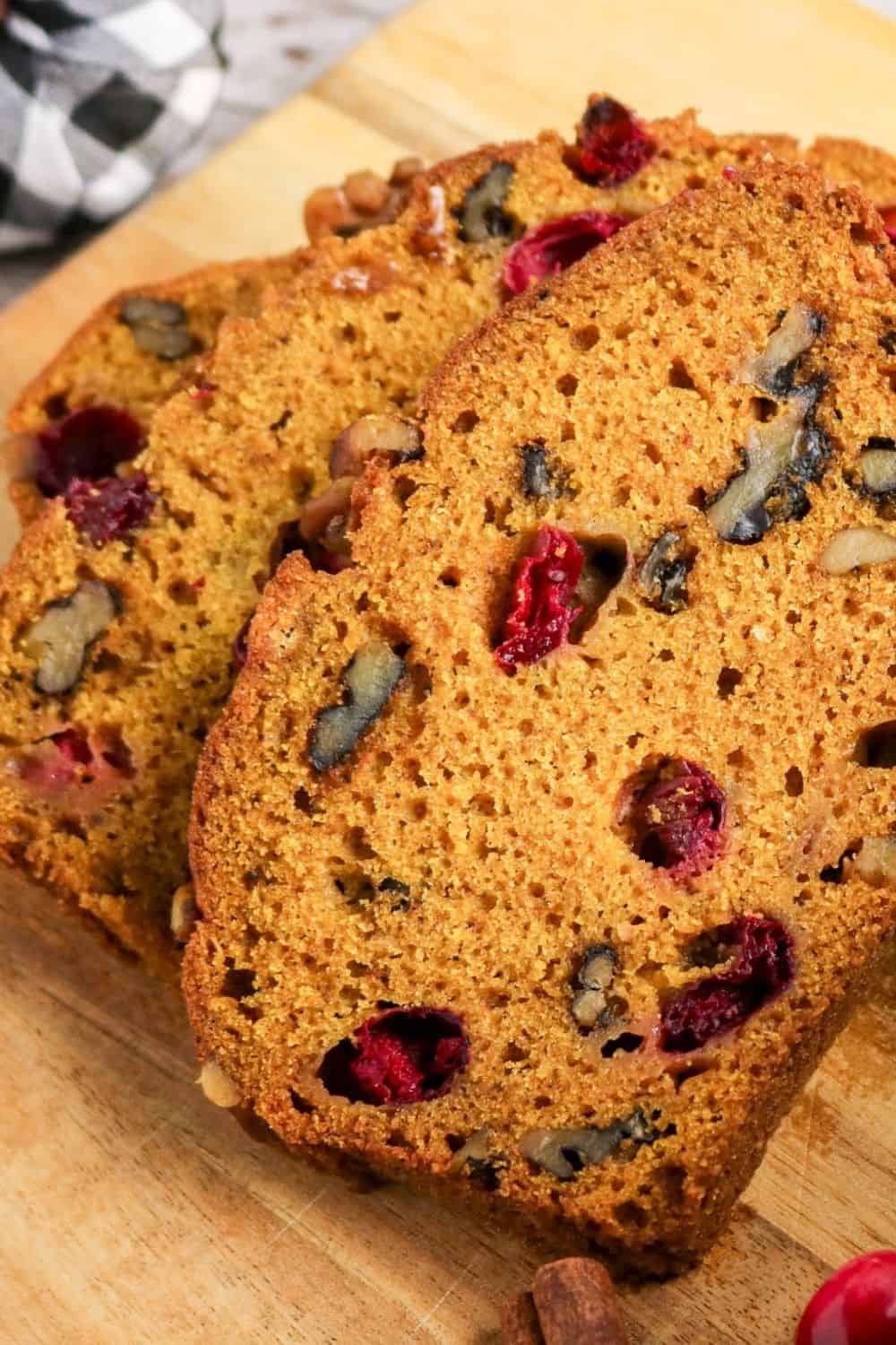 Close-up view of pumpkin cranberry nut loaf, showing the moist crumb, soft berries, and crunchy nuts.