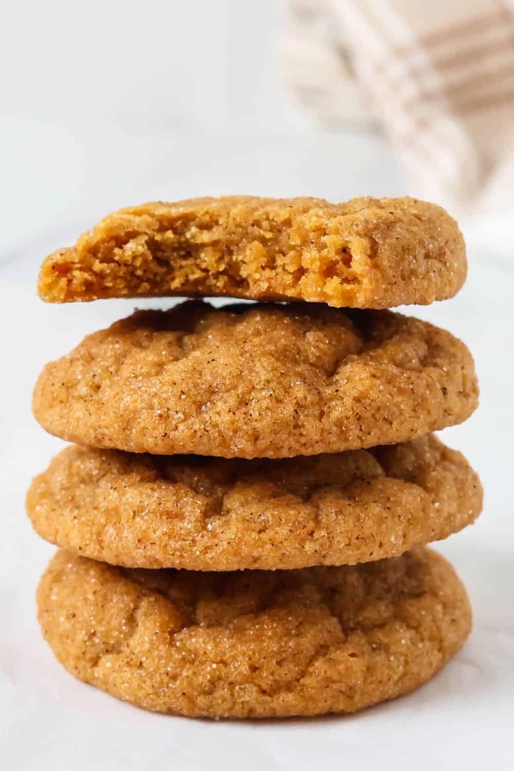 Stack of pumpkin molasses cookies; the top cookie has a bite taken out of it.