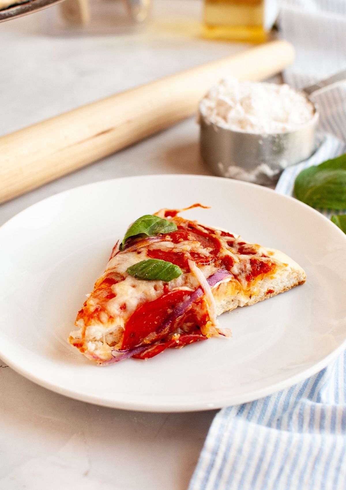 Slice of pizza made with Bisquick pizza crust, served on a white plate.