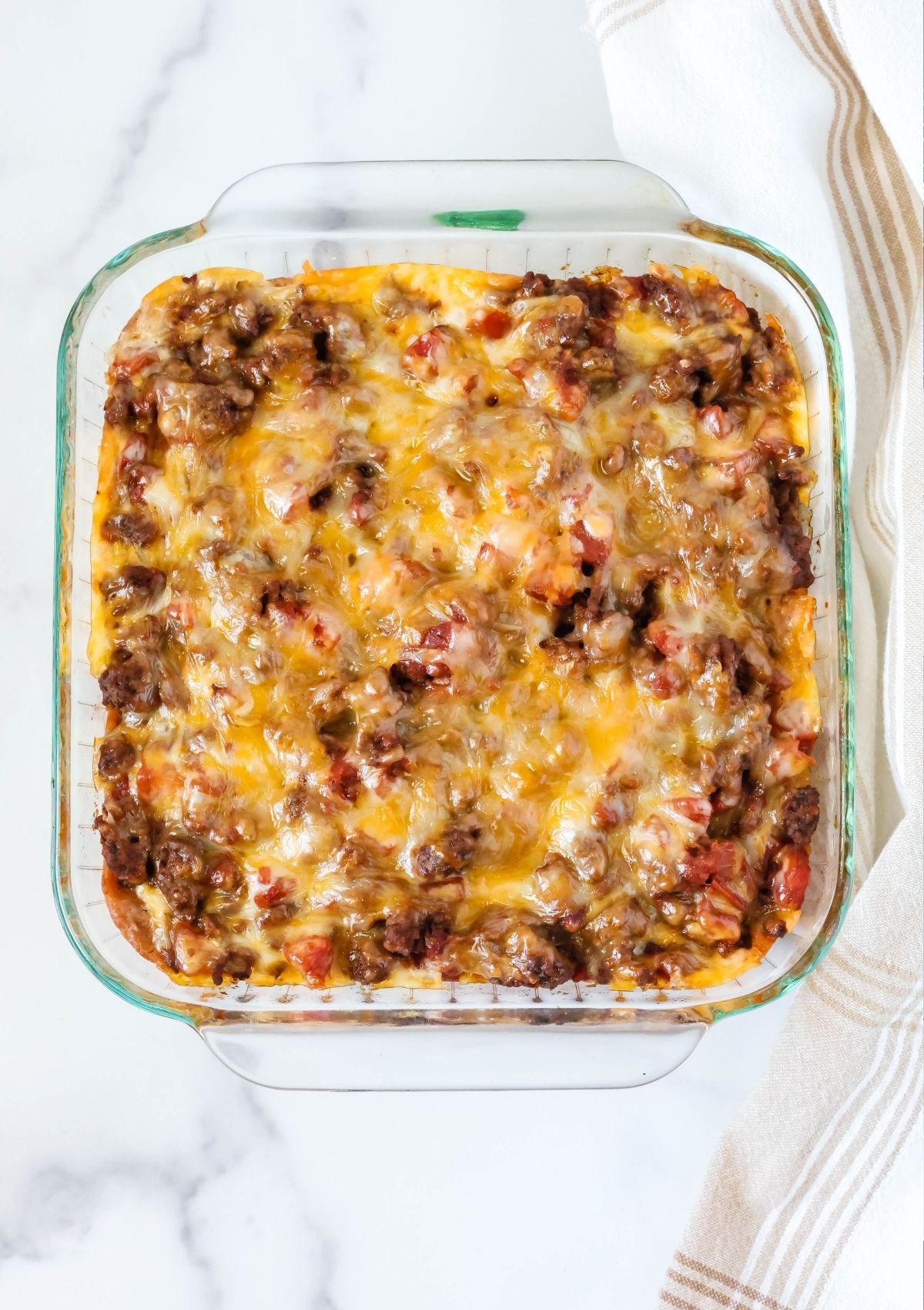 Overhead view of a glass 8x8-inch casserole dish filled with taco casserole made with Bisquick.