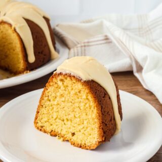 Slice of brown sugar pound cake from a mix, topped with brown sugar icing, served on a white plate.