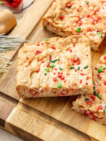 Cake mix Christmas cookie bars on a wooden cutting board.
