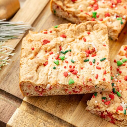 Cake mix Christmas cookie bars on a wooden cutting board.