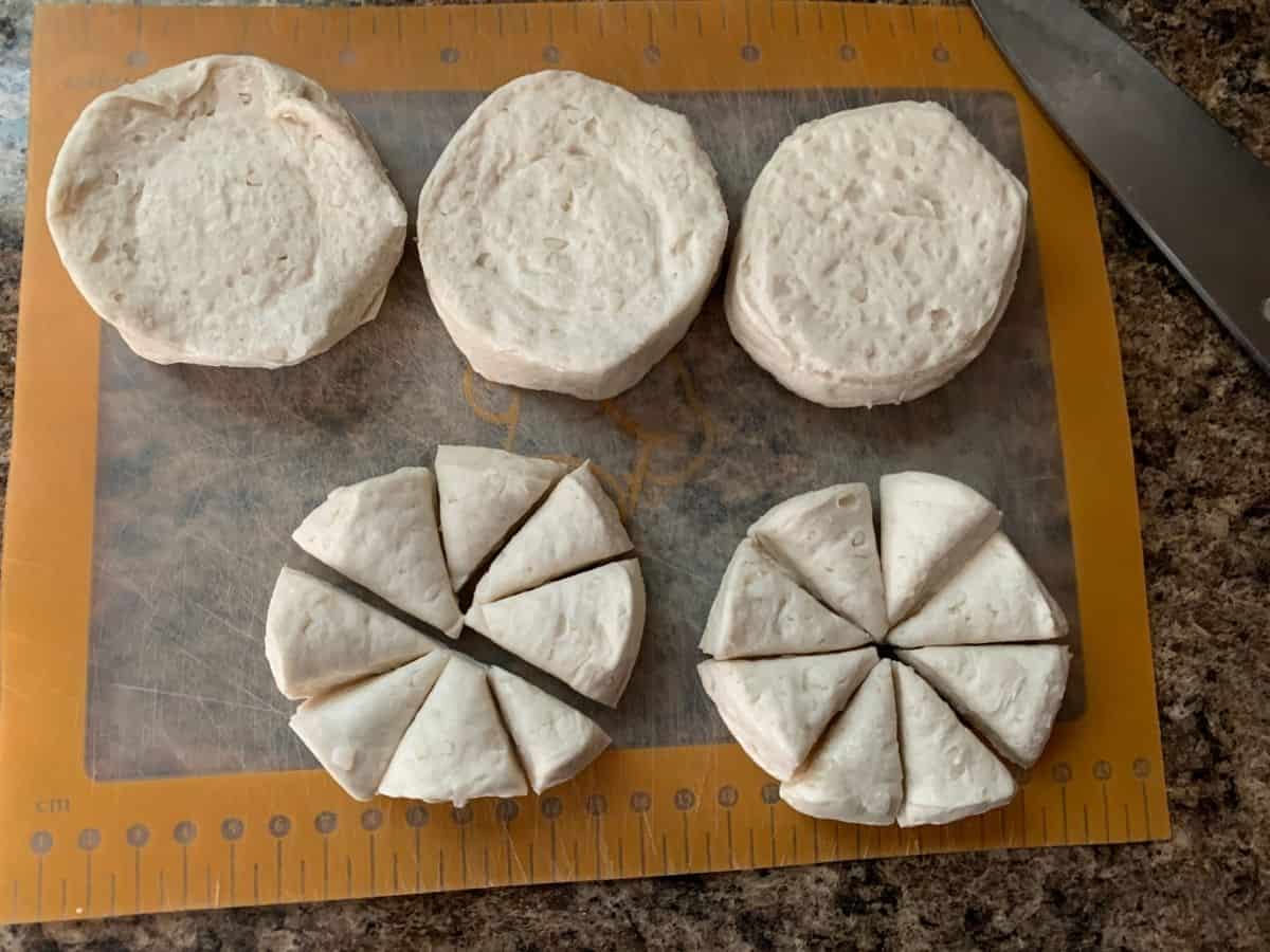 Canned biscuits on a cutting board, cut into pieces for making chicken and dumplings