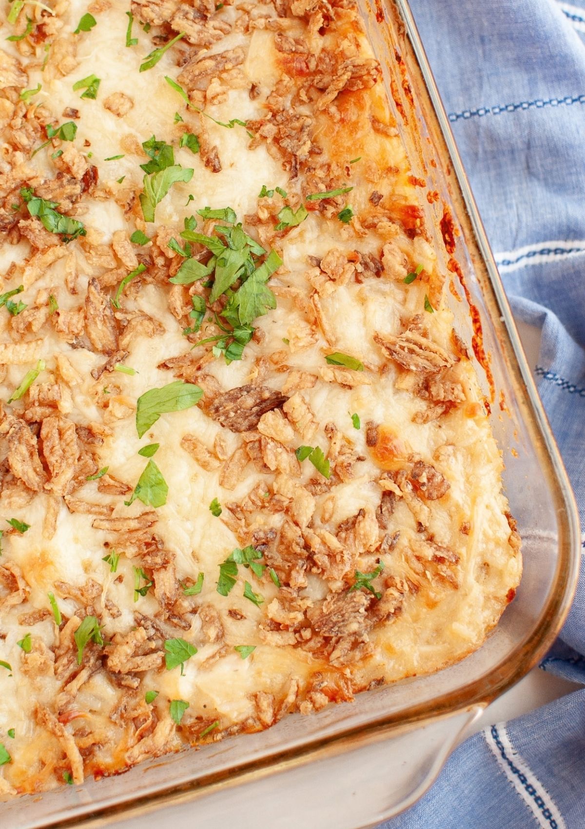Overhead view of part of a glass baking dish filled with cheesy french onion chicken and rice casserole.