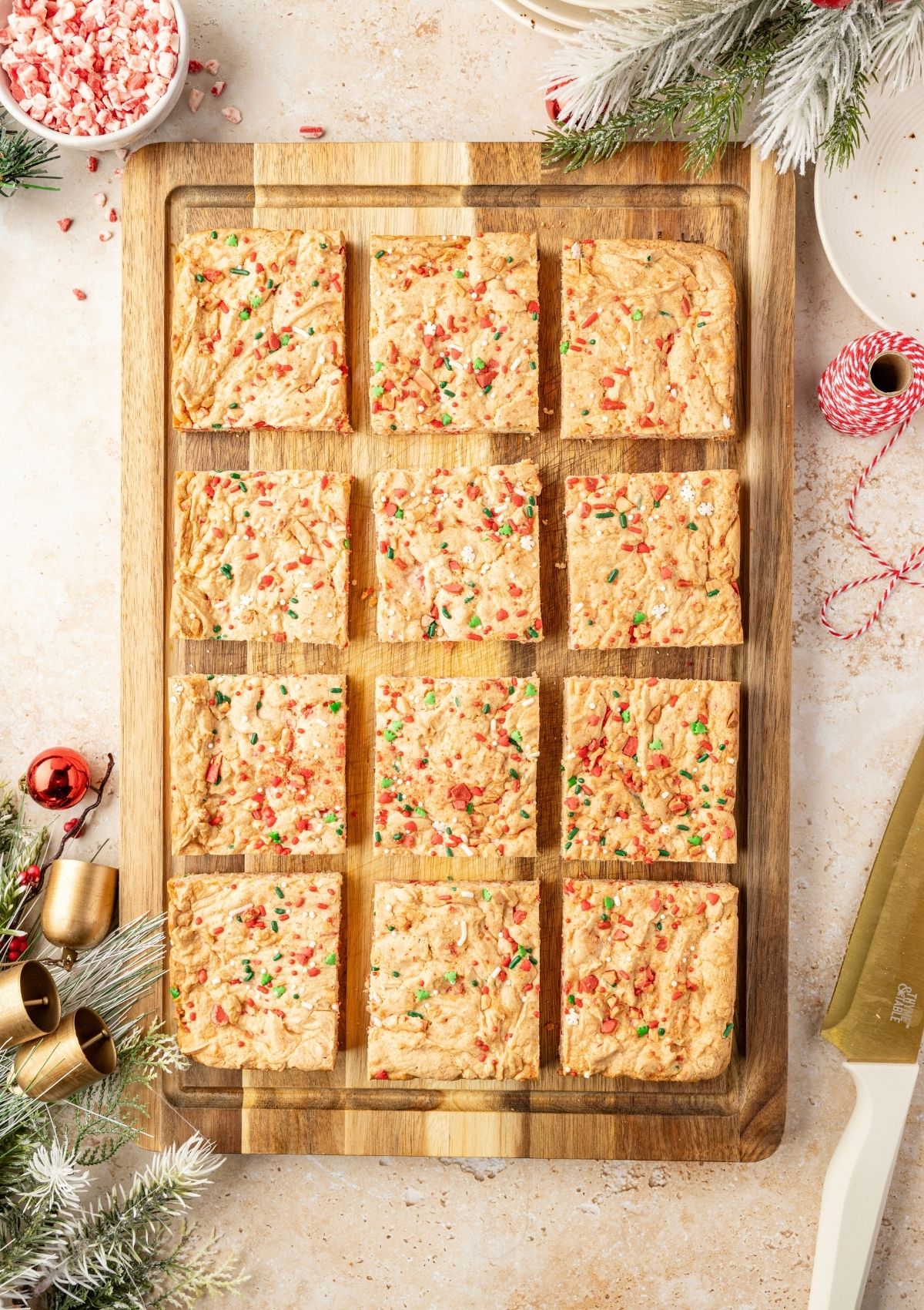 Overhead view of Christmas dessert squares made with cake mix, displayed on a wooden cutting board.