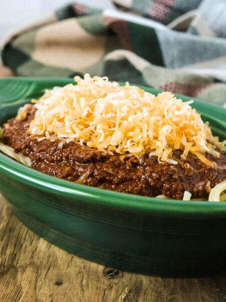 Cincinnati chili (copycat Skyline chili) served over spaghetti and topped with shredded cheese.