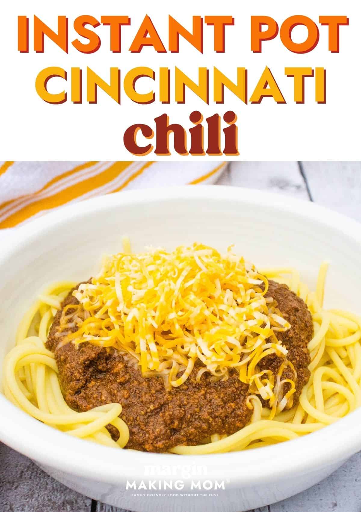 white bowl filled with spaghetti topped with Instant Pot Cincinnati Chili and shredded cheese