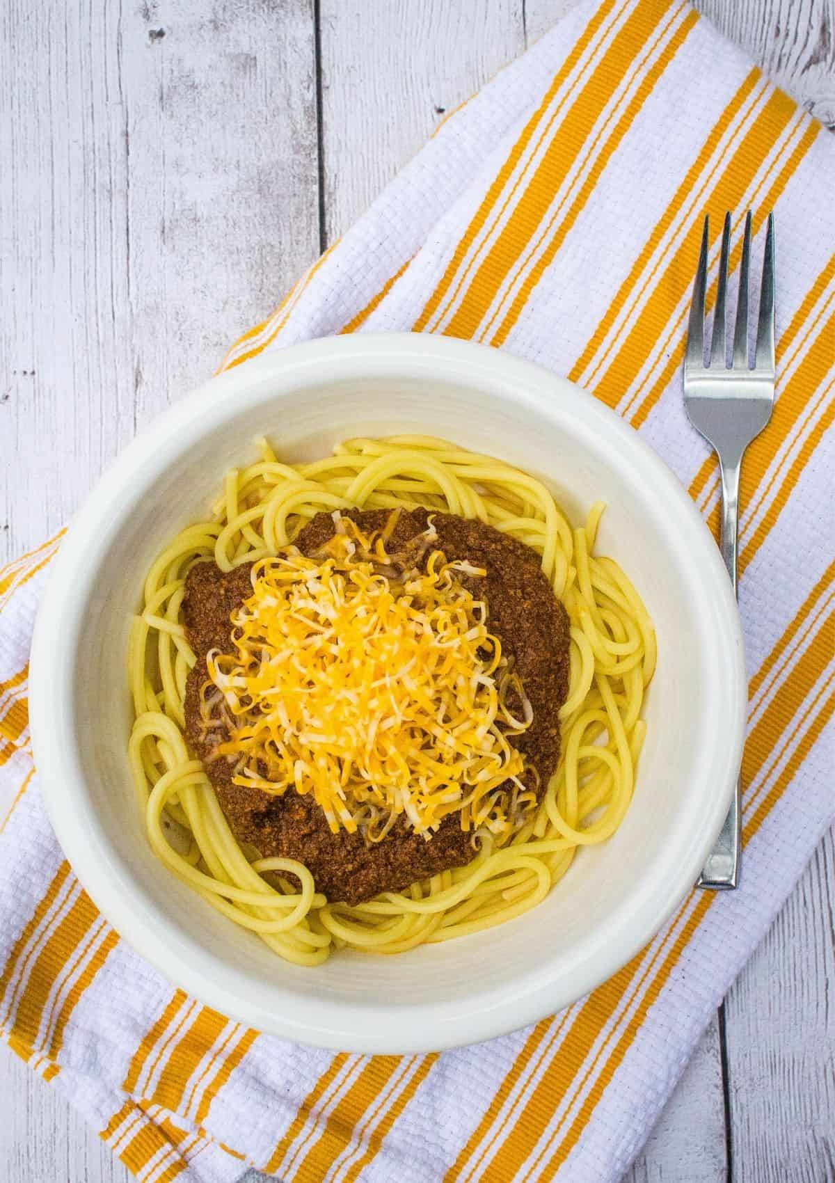 Overhead view of a white bowl filled with spaghetti and cincinnati chili made in the Instant Pot