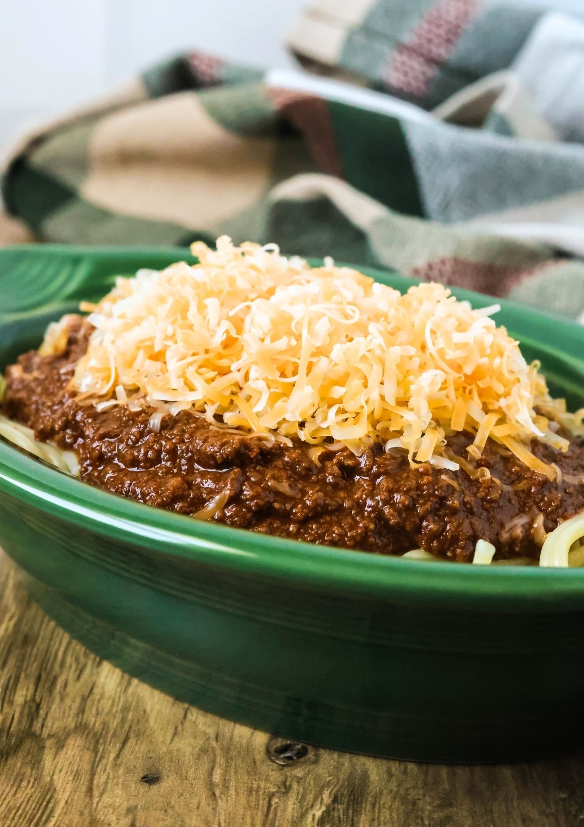Side view of a green dish with copycat Skyline chili served in it.