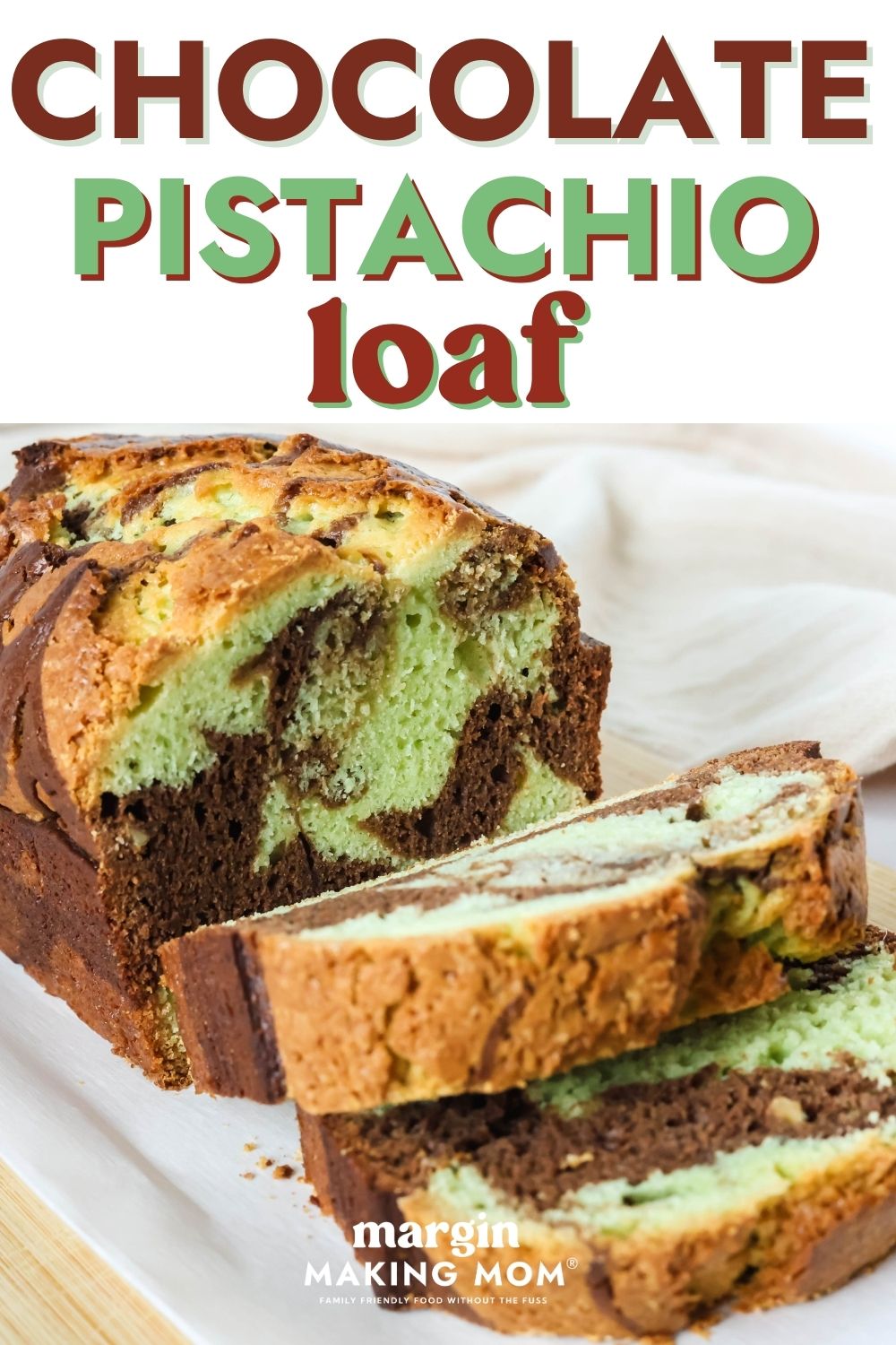 Side view of chocolate pistachio loaf that has been partially sliced, showcasing the marbled interior.
