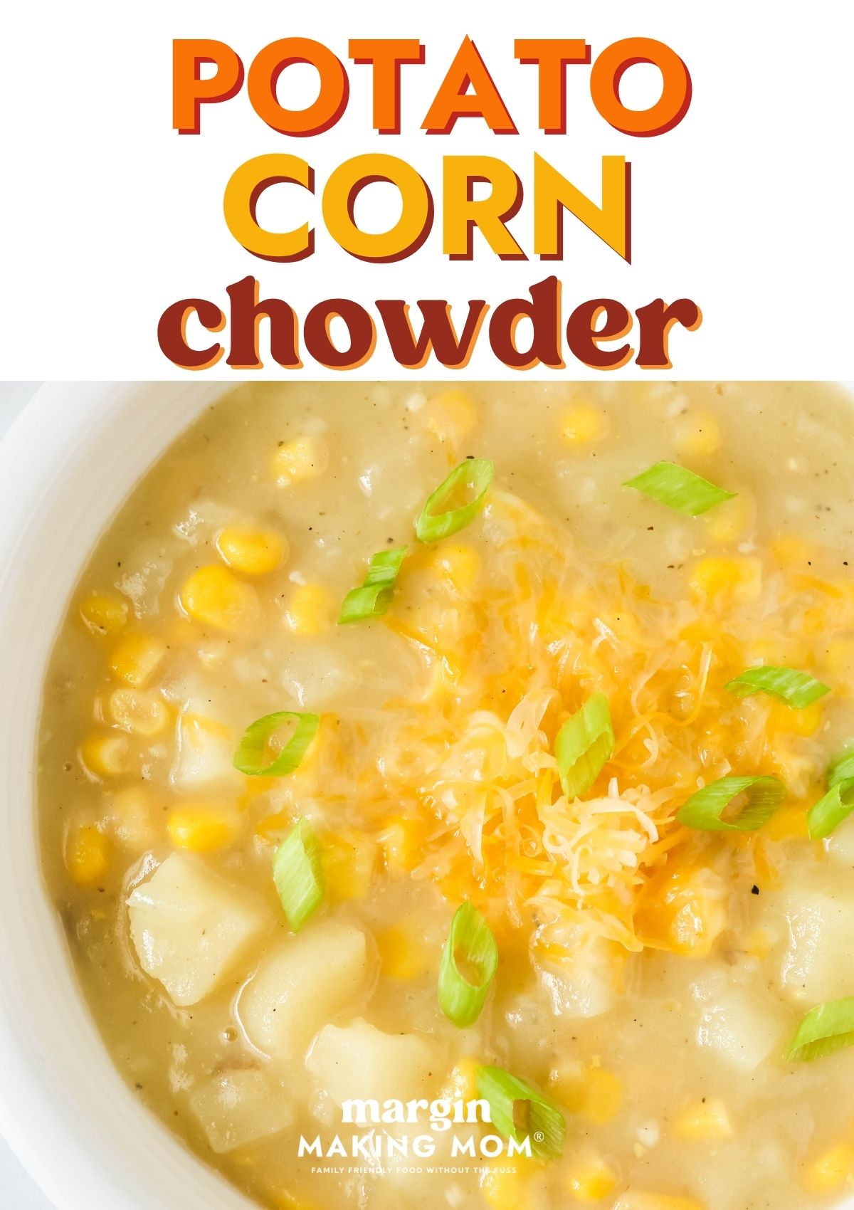 Close-up view of potato corn chowder in a white bowl, garnished with cheese and green onions.
