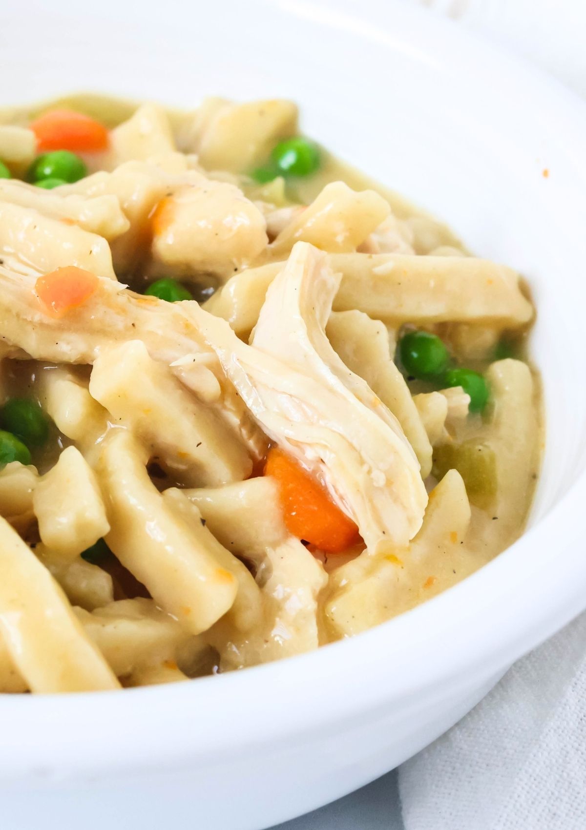 Close-up view of Instant Pot creamy chicken noodles served in a white bowl.