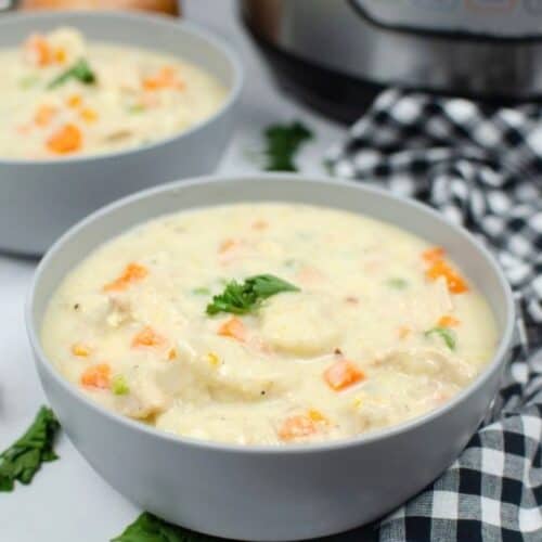 two bowls of Instant Pot chicken and dumplings made with biscuits, placed in front of an Instant Pot pressure cooker