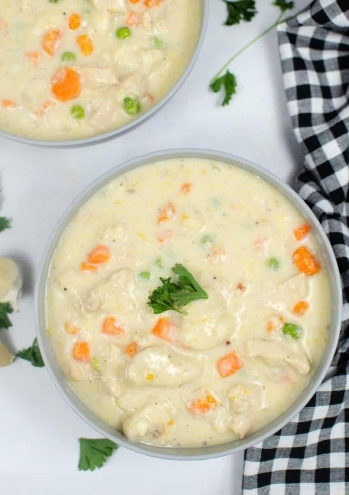 two bowls of chicken and dumplings made with canned biscuits and cooked in the Instant Pot pressure cooker
