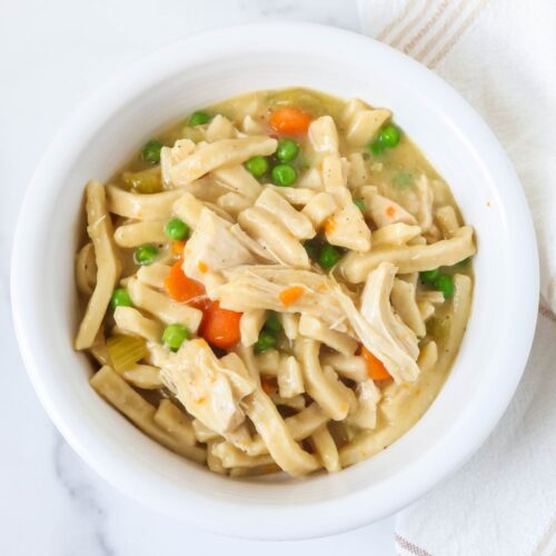 Instant Pot chicken and noodles served in a white bowl.