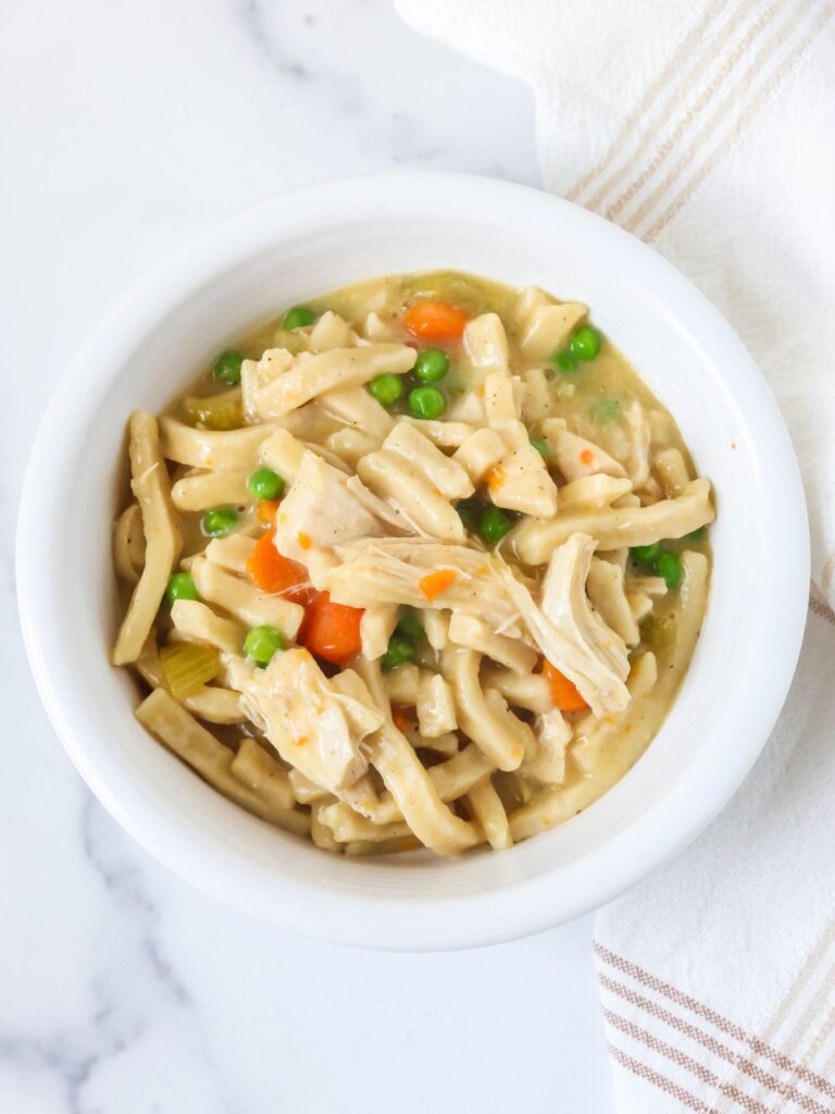 Instant Pot chicken and noodles served in a white bowl.