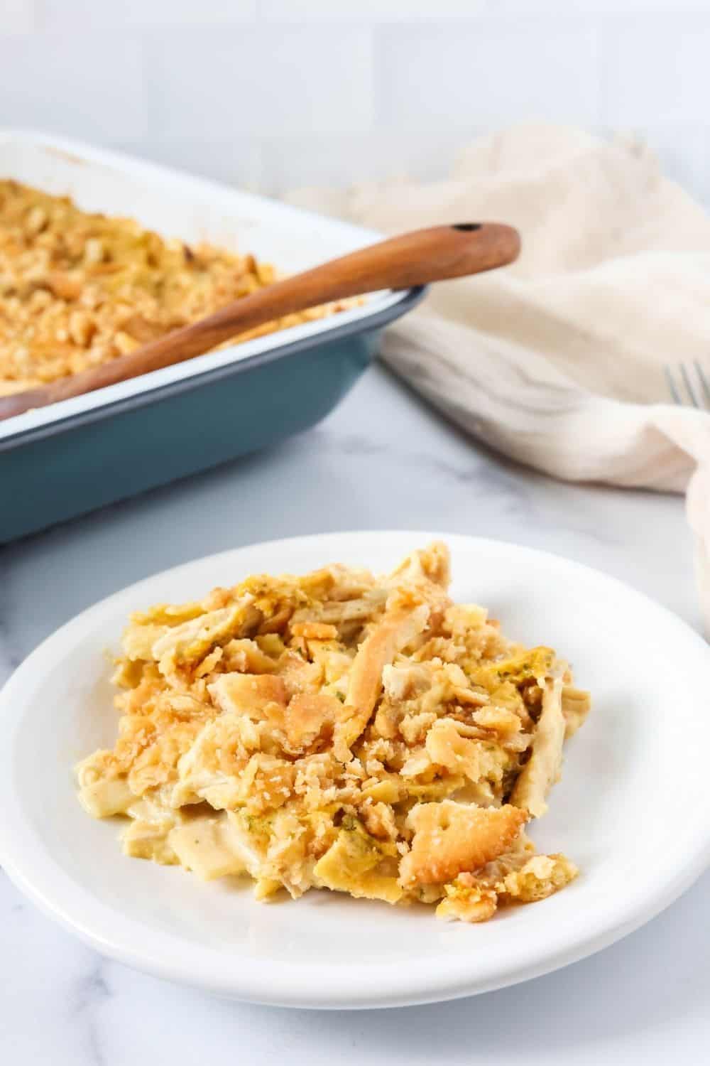 A white plate with a serving of Knorr chicken casserole. The casserole dish is in the background.
