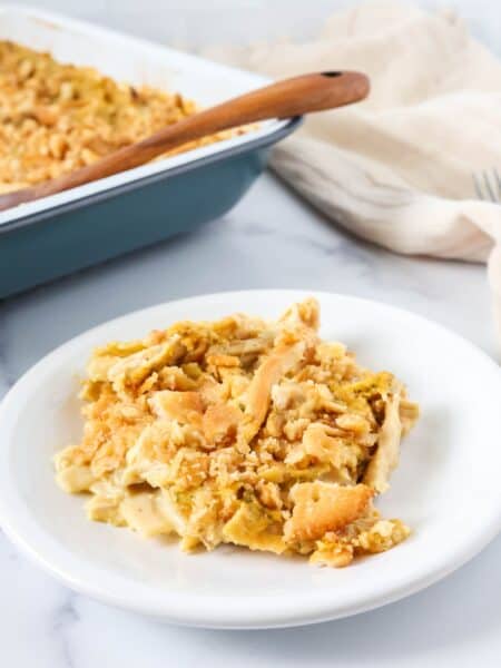 Knorr chicken noodle casserole served on a white plate, with a casserole baking dish in the background.