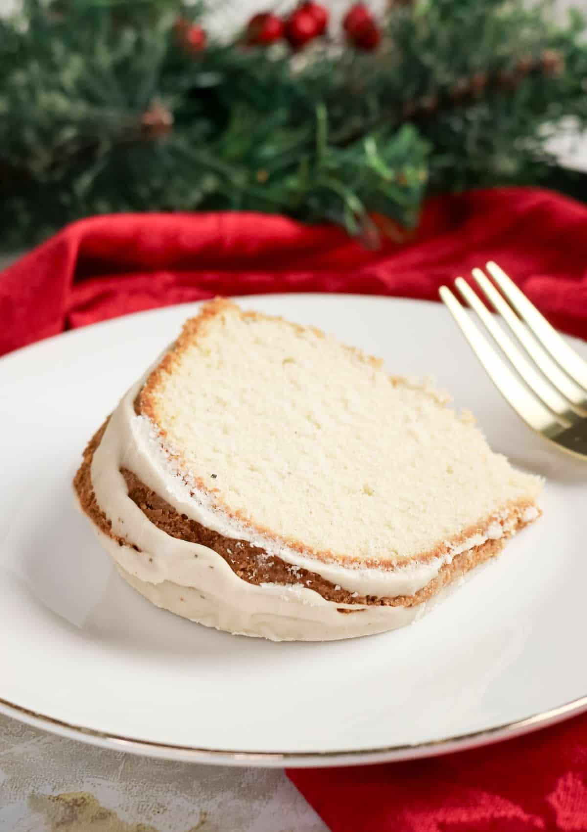 Close-up view of a slice of pound cake made with eggnog, served on a white plate.