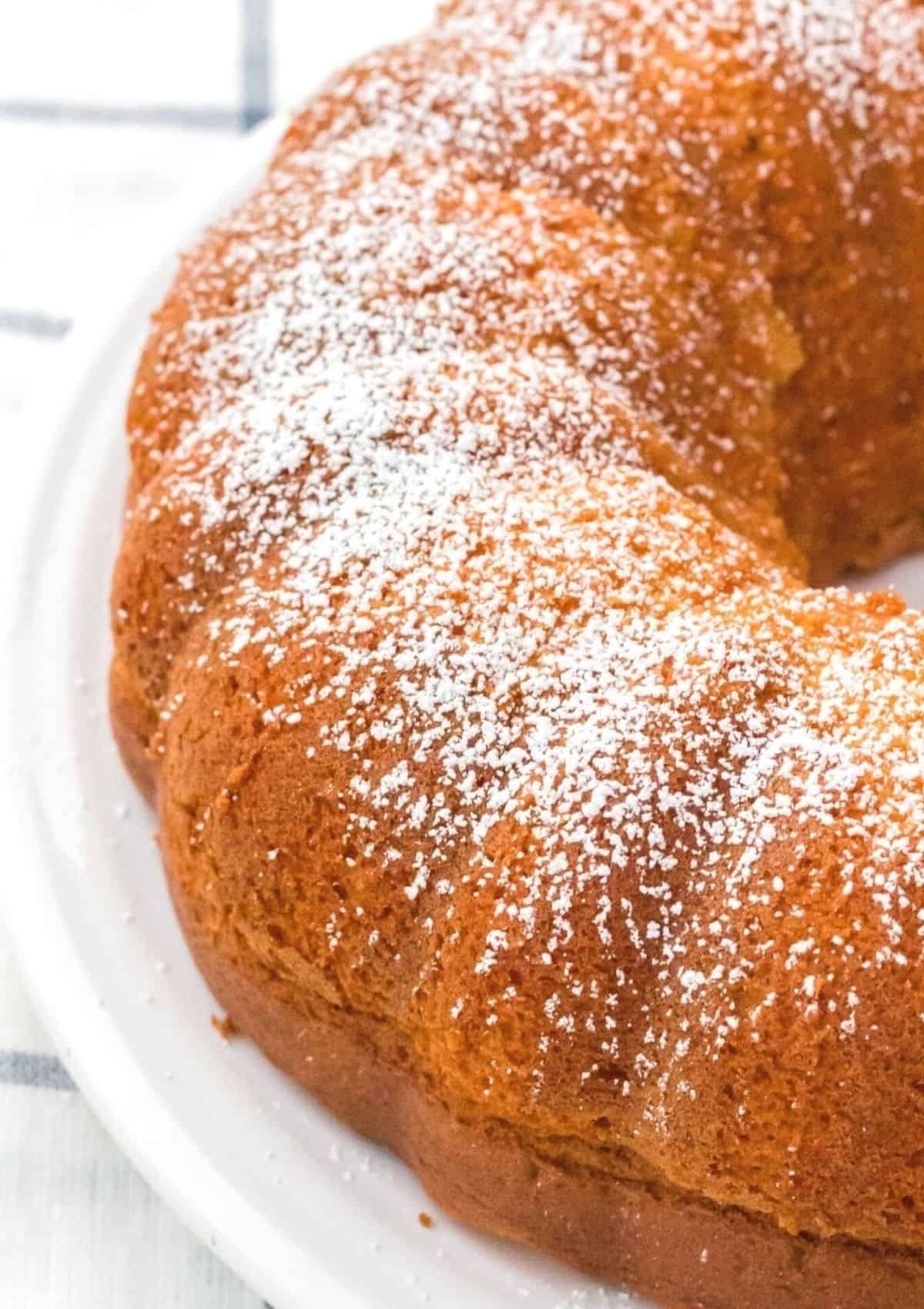 side of a vanilla pudding bundt cake, dusted with powdered sugar