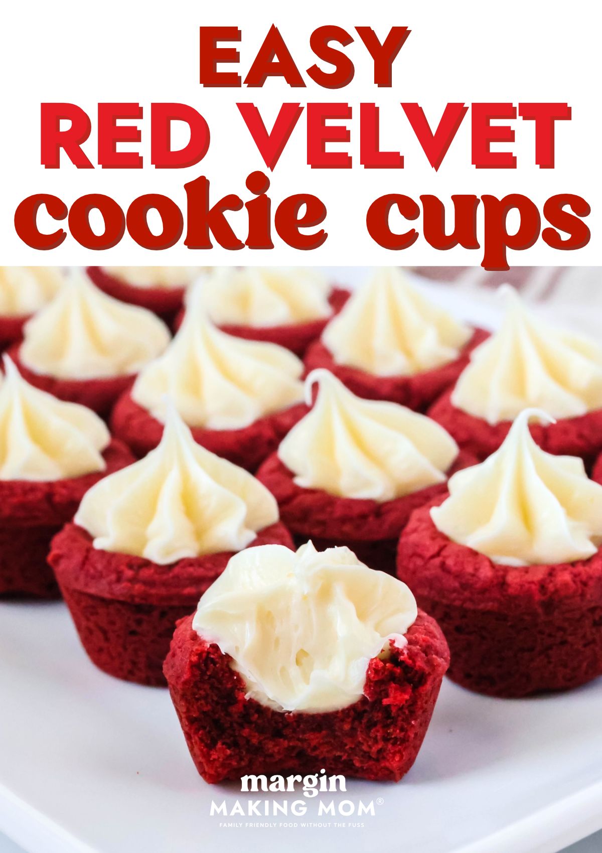 Several red velvet cookie cups served on a white plate, one of which has had a bite taken out of it to show the texture of the cookie cup and frosting.