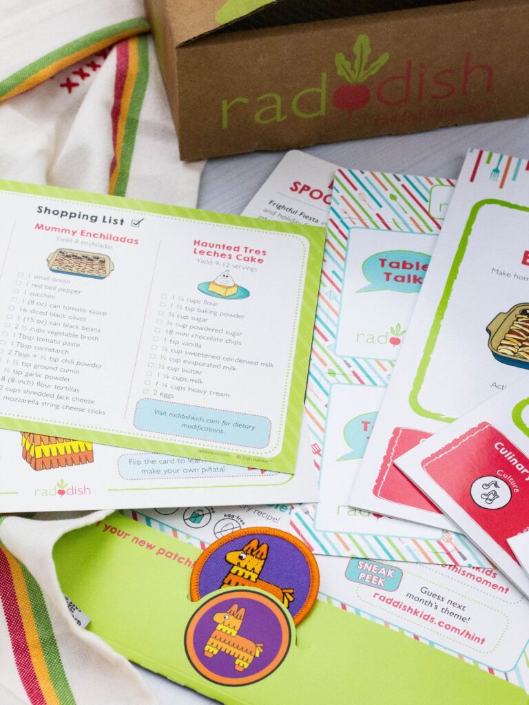 printed materials from a Raddish Kids cooking box are laid out for viewing.